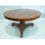 An early-19th century rosewood circular tilt-top dining table, the top on triform tapered column and