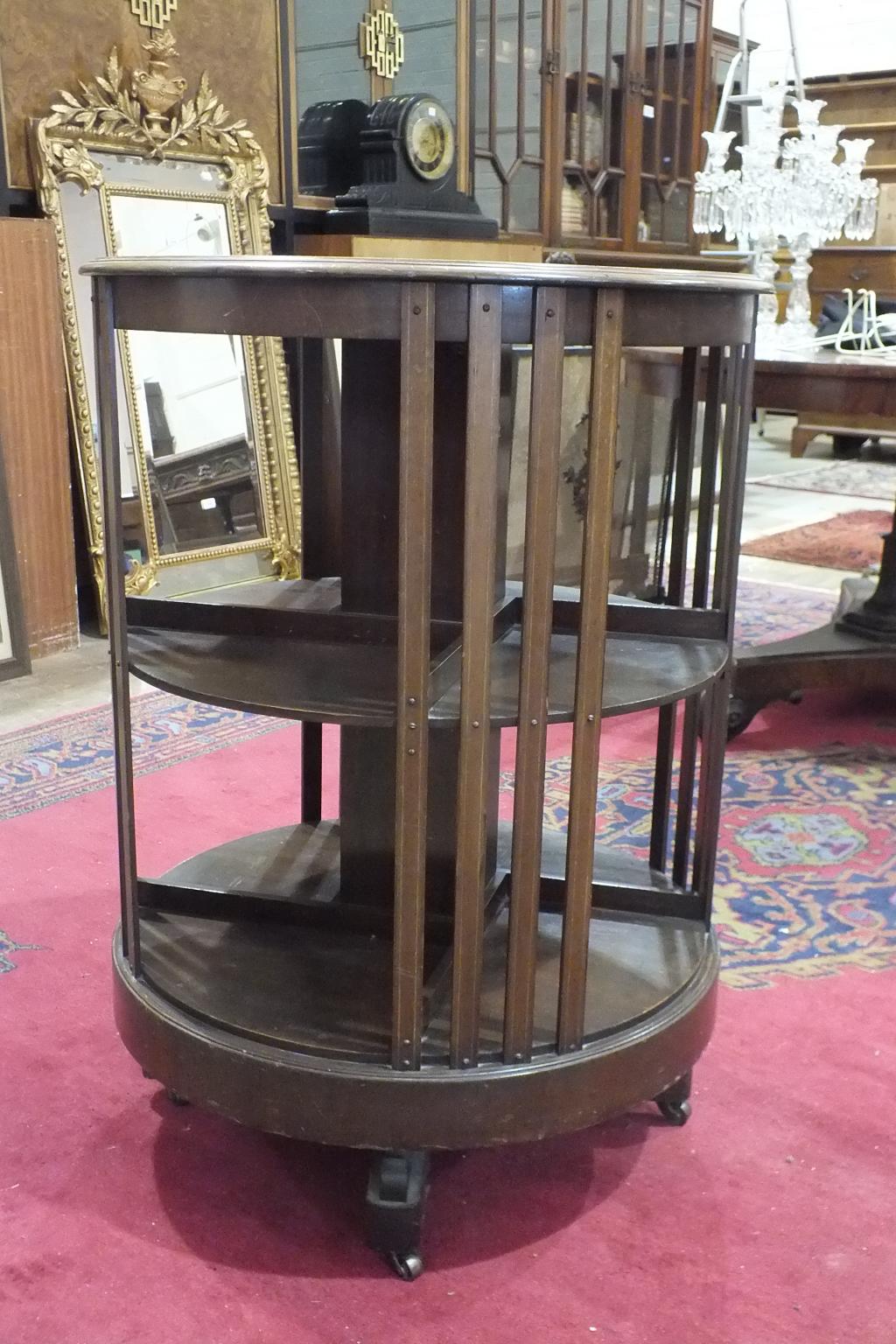 An early-20th century inlaid mahogany circular revolving bookcase, 62cm diameter, 86cm high.