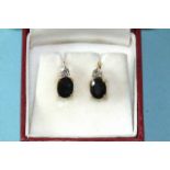 A pair of sapphire and diamond earrings, each set an oval sapphire below a brilliant-cut diamond,