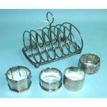 A six-division wire toast rack, Sheffield 1884, (damaged) and four silver napkin rings.