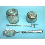 A cut-glass dressing table jar, the silver top embossed with a courting couple, Birmingham 1915, a