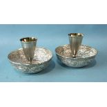 A pair of small Russian white metal and gilt spirit cups on circular bases and two embossed white