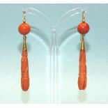 A pair of Victorian coral earrings, each with carved coral tear-drop pendant below a coral cabochon,