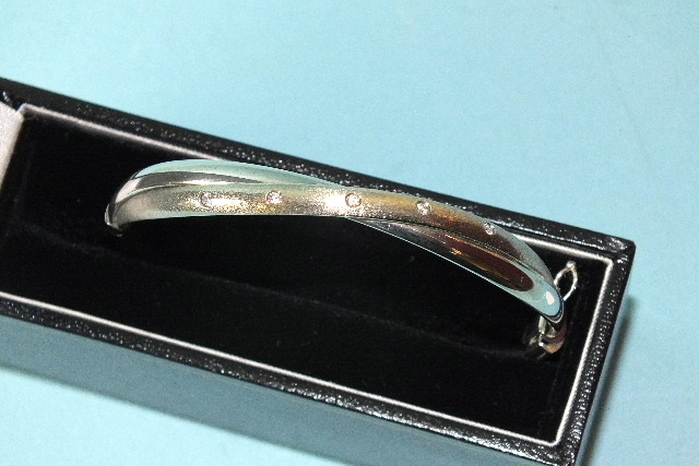 A 9ct white gold hinged bangle set five white stones, 56 x 50mm inside measurement, 6.4g, boxed.