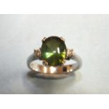 A green tourmaline and diamond ring, the dome-top tourmaline of approximately 2.52cts, claw-set