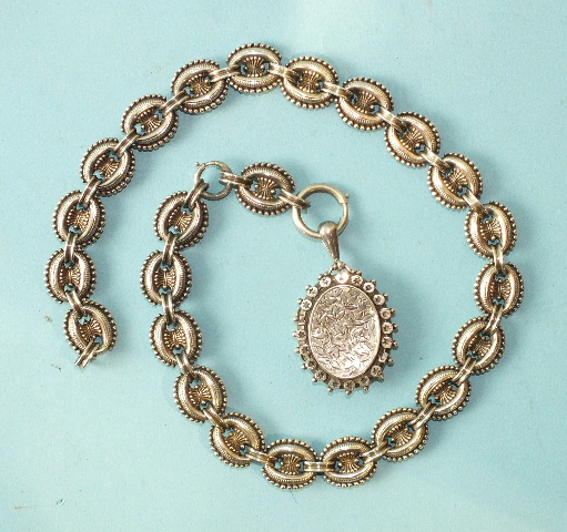 A Victorian silver locket on unmarked oval beaded-link chain, 49.5cm long.