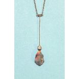 An Edwardian black opal and diamond necklace claw-set a pear-drop opal, below a millegrain-set