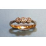 A three-stone diamond ring millegrain-set three brilliant-cut diamonds, in 18ct yellow gold and