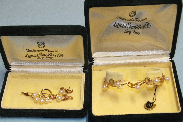 A 14k gold bracelet set Mikimoto cultured pearls, boxed and a 14k gold brooch and matching