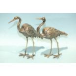 A pair of models of standing herons, indistinctly marked, 16cm high, (2).