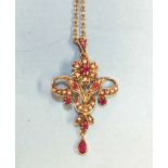 An Edwardian-style open-work pendant of flower and scroll form set round-cut rubies and seed pearls,