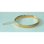 A 15ct gold hinged bangle bearing inscription, (damaged), 11.4g.