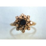 A sapphire and diamond cluster ring set a round-cut sapphire and sixteen 8/8-cut diamonds, in