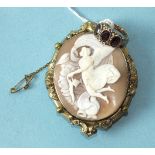 A shell cameo brooch depicting an angel and a three-stone garnet ring, unmarked, (2).