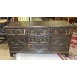 An antique oak low sideboard, the rectangular top above an arrangement of five drawers and two