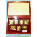 Hallmark Replicas Ltd., a cased set of seven silver gilt stamp medallions, To Commemorate the 25th