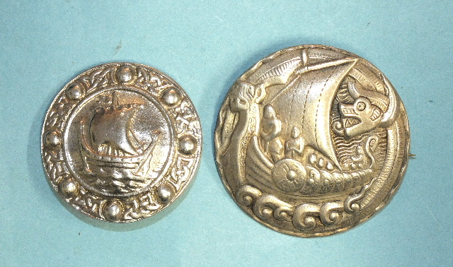 A circular silver Viking ship brooch marked 'Silver', 3.6cm diameter and another, similar, marked '