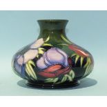 A Moorcroft vase of squat form decorated with anemones on a green ground, 10.5cm high, factory