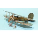 A trench art brass model of a biplane, 9cm long, a trench-art-style brass and copper model of a