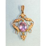 An Edwardian amethyst and seed pearl open-work pendant, with oval amethyst within scrolls of seed