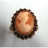 A cameo ring, the shell cameo of a young woman, in garnet-set border, on 9ct gold mount, size K½,