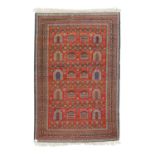Orientteppich. PAKISTAN, 20. Jh., 214x142 cm.Rotgrundiges Innenfeld mit geometrischer Musterung,