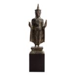 Stehender Buddha aus Bronze. THAILAND, 20. Jh..Auf einem quadartischen, getreppten Sockel stehend.