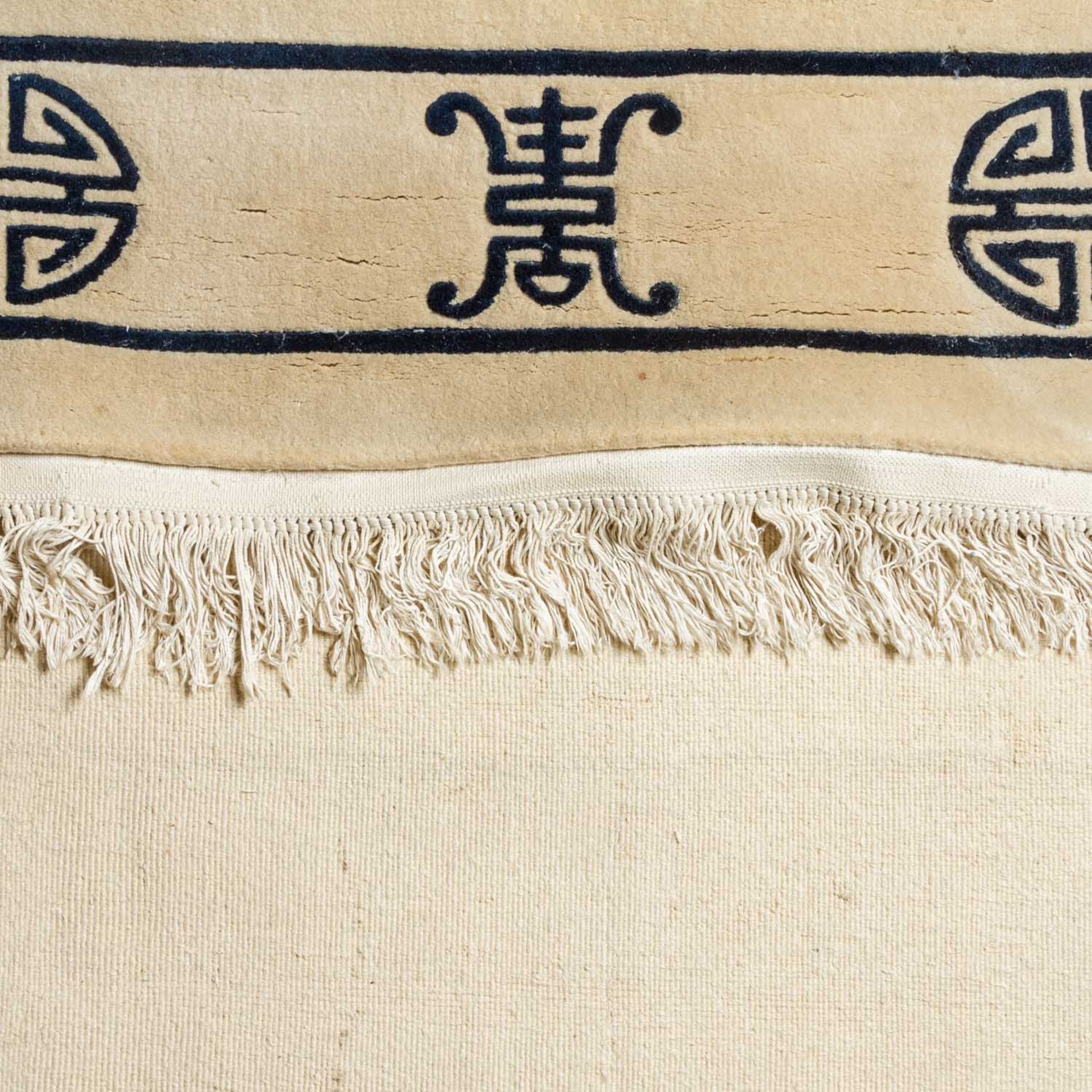 Teppich aus Wolle. CHINA, 20. Jh., 290x185 cm.Der uni beigefarbene Fond zeigt ein reduziertes Muster - Bild 3 aus 4