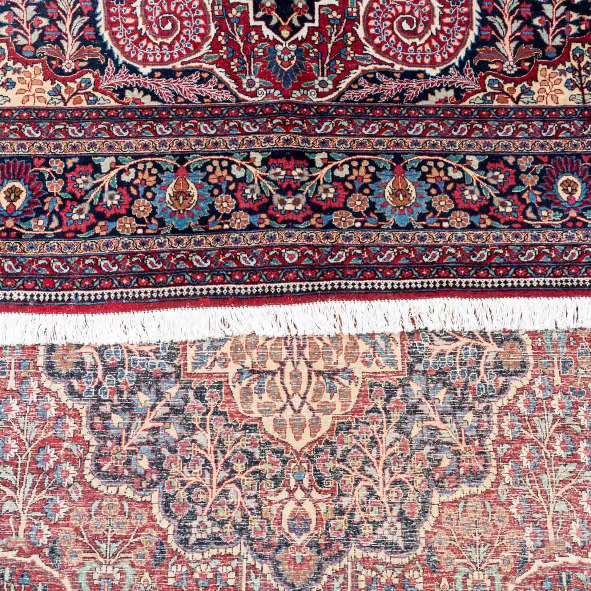 Orientteppich. MASCHAD-AMOGHIL/PERSIEN, 20. Jh., 350x250 cm.Der rote Fond des Innenfeldes ist mit - Bild 3 aus 4