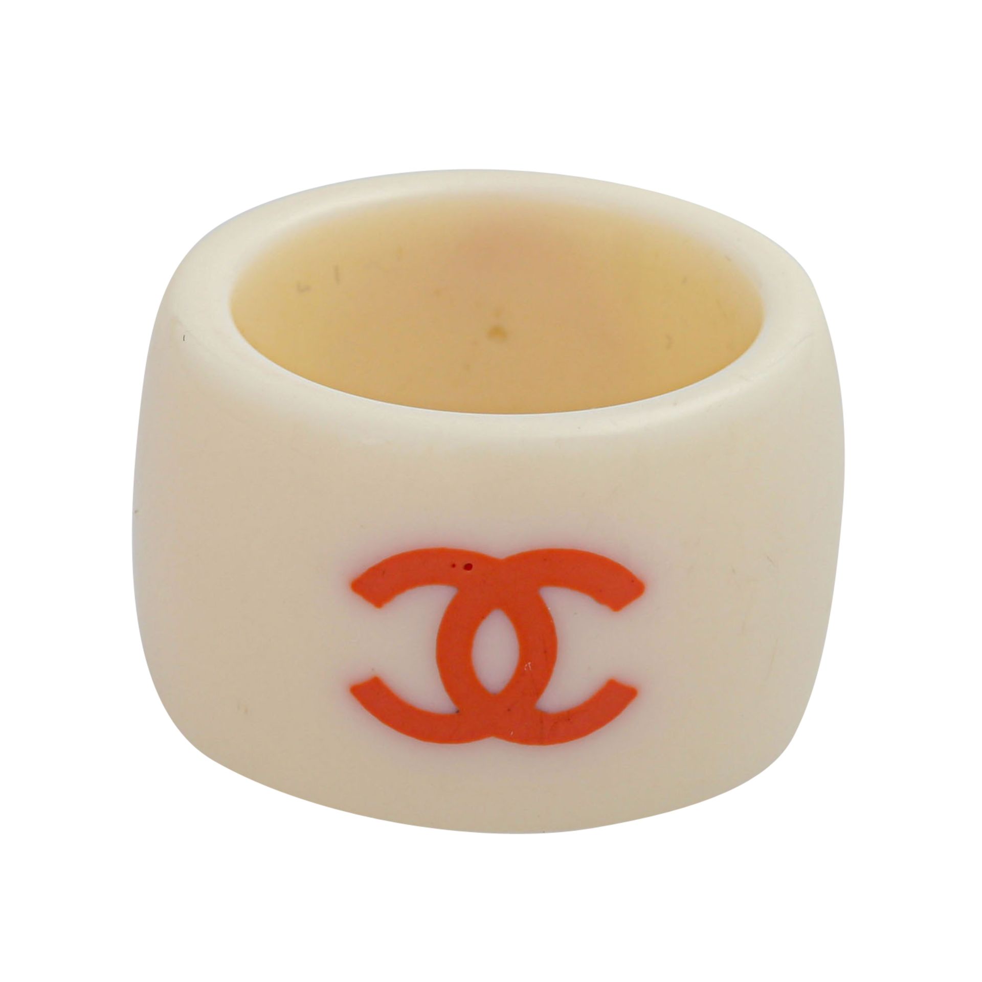 CHANEL Modeschmuck-Ring "CAMELIA", Koll. 2003.Kunststoff in Eierschalenfarbe mit rostrotem CC-Logo