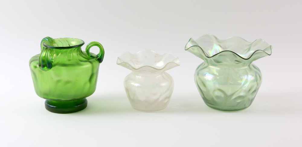 Three Austrian Art glass vases, a green iridescent three handled vase, with flared rim, on footed