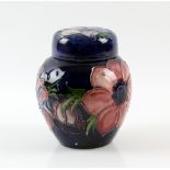 Moorcroft jar and cover in anemone pattern on a blue ground, bearing two paper labels, 'Potters to