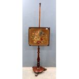 A mahogany polescreen with tapestry panel..