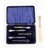Silver-mounted manicure set, cased, and a Victorian silver-mounted ivory page-turner (2)PLEASE NOTE:
