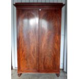 19th century mahogany wardrobe with panelled doors on turned feet,.