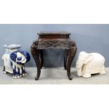 Two ceramic garden seats each in the form of elephants and a carved occasional table. (3).