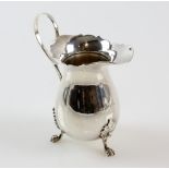 Silver cream jug, with flared rim and three paw feet, 9 cm high.