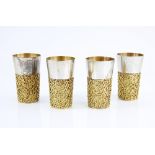 Elizabeth II set of four silver and silver-gilt beakers, the lower body applied with openwork gilt