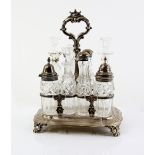 Victorian silver cruet stand with shell and scroll central loop handle, with eight cut glass bottles