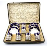 Set of six Coalport porcelain blue, white and gilt coffee cups and saucers, in silver holders with