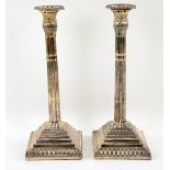 George III pair of silver candlesticks, the acanthus leaf topped lobed columns on a square stepped