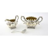 William IV silver cream jug and sugar bowl of lobed form with scroll handles on four shape feet,