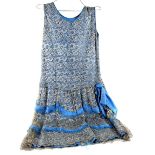 1920's drop waisted, dress of blue silk overlaid with silver lace, the skirt with tasseled ribbon,