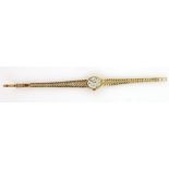 Gold Tissot watch, with oval dial and baton markers, on gold bracelet strap, marked 9 ct . Gross