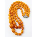 Double row amber necklace, graduated oval beads, largest measuring 21 x 18 mm, strung without knots,