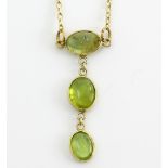 Tourmaline and gold necklace, three tourmalines rub over set into a drop, mounted in 9 ct yellow