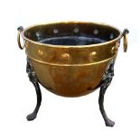 An Aesthetic Movement coal bucket in brass, with studded detail, ring handles, cast iron legs with