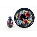 Moorcroft pottery baluster vase, the blue ground with floral decoration, on round foot, paper