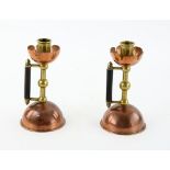 Pair of copper and brass Candlesticks, each with petal wax tray brass column, ebonised wood