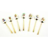 Enamel silver gilt spoons each painted with a different arrangement of flowers .
